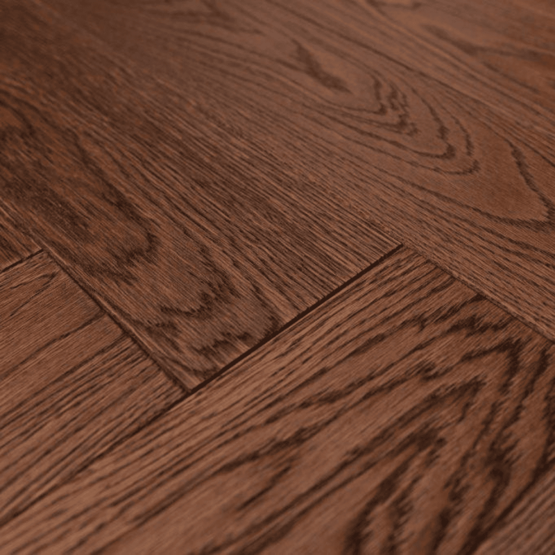 Suprafata parchet stratificat herringbone culoare maro cu supratafa periata, ulietata si bizotat pe patru laturi pentru pardoseala sau pereti.